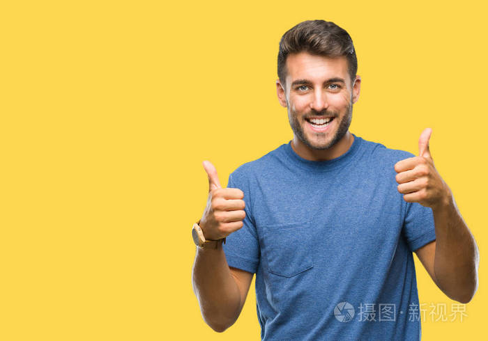 年轻英俊的男人越过孤立的背景成功标志,做积极的手势,用手竖起大拇指