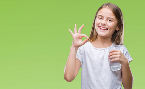 年轻漂亮的女孩喝着一杯水，在孤立的背景下，用手指做OK标志，很好的象征