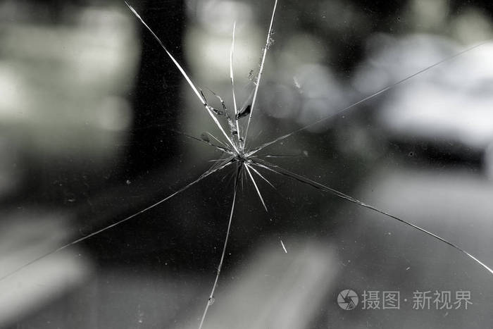 蛛网裂缝破碎玻璃的抽象背景. 破碎玻璃裂缝的纹理. 关上一个破裂的玻