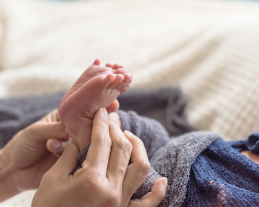 把婴儿的脚关在妈妈手里。 妈妈和她的亚洲孩子。 幸福的家庭观念。 母性的宏观形象