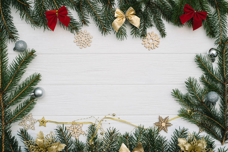 圣诞树上有装饰，在木制背景上闪闪发光。 白色木制书桌上的圣诞背景
