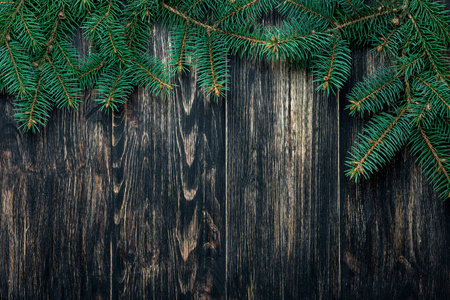 云杉树枝在黑暗的老式木制背景上。 圣诞节概念