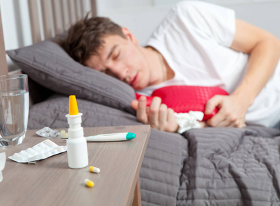 躺在床上咳嗽的男人感觉不好照片