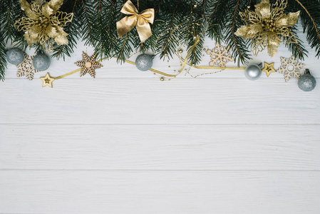 圣诞树上有装饰，在木制背景上闪闪发光。 白色木制书桌上的圣诞背景