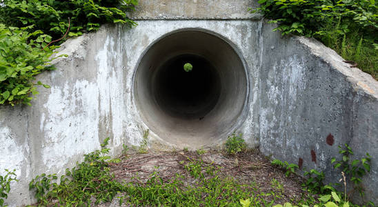 大型隧道水泥管作为污水雨水通道。 黑暗的洞穴隧道。 城市隧道。 圆形隧道。 隧道水泥管有黑影