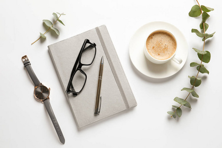 平躺式构图，配有笔记本咖啡杯和白色背景的手表