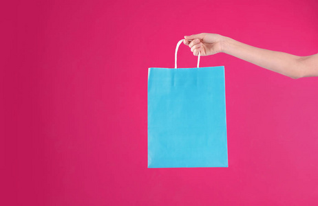 女人拿着购物袋在彩色背景特写。 设计模拟