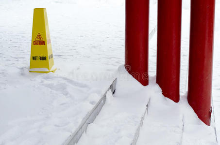 雪地板上的黄色塑料湿地板标志。