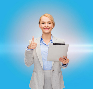 一个微笑的女人举着大拇指对着平板电脑