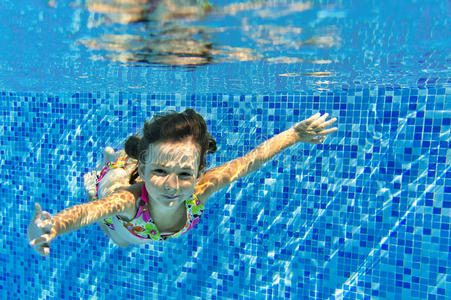 快乐微笑的女孩在游泳池里游泳