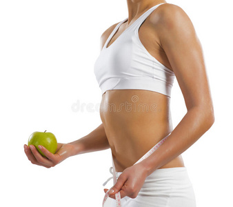 举着一个青苹果的年轻运动妇女