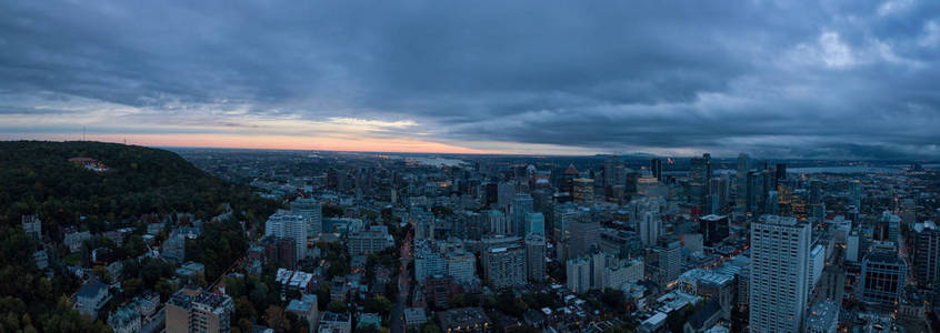 在一个引人注目的多云日出期间，一个美丽的现代市中心城市的空中全景。 摄于加拿大蒙特利尔魁北克。
