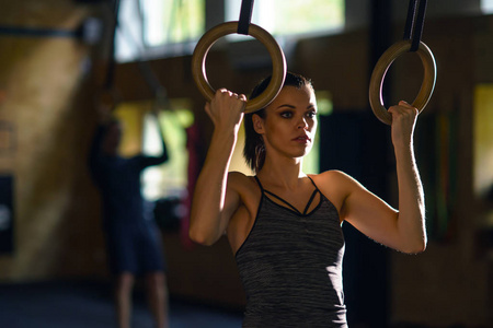 适合运动和运动的女运动员在健身房工作。 女子训练使用体操环。 体育生活方式体育和健身理念。