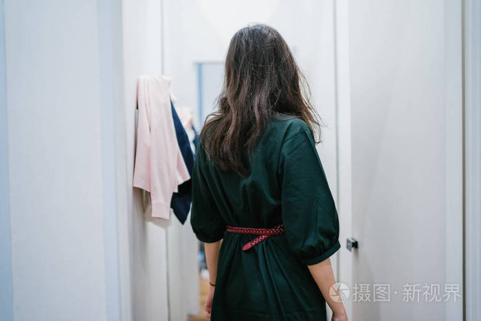 一位年轻美丽的印度亚洲妇女在商场时装店的试衣间试穿新衣服的肖像