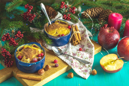 圣诞节和新年作文与甜，美味的苹果，甜点，云杉枝，餐具，蓝色绿松石木桌表面，复制香料，节日背景，圣诞餐桌，地点设置。