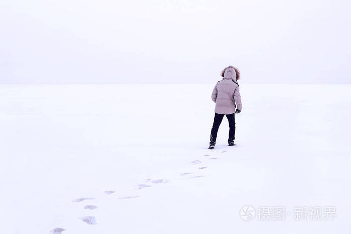 男人走在雪地上的脚印后面. 寒冷的西伯利亚冬天. 俄罗斯.