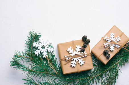 白色背景的圣诞礼物，冷杉枝和木制雪花，寒假概念