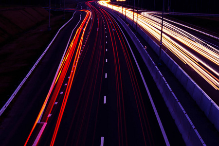 汽车在夜间在弯曲的公路上轻步. 夜间交通通道. 动作模糊.