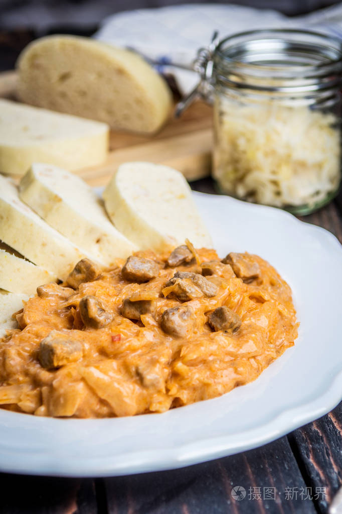 传统的匈牙利古拉什(szegulyas z),猪肉,腌制的白菜和木桌上的饺子