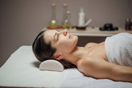 美丽的年轻白种人女人躺在按摩台上.照片