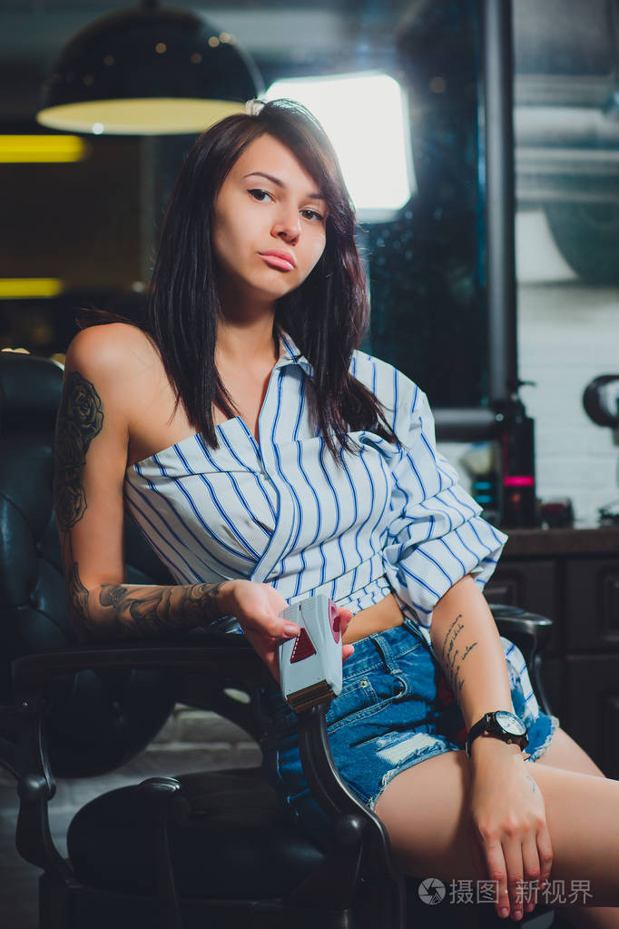 女理发师剃须男人的胡子在理发店的肖像