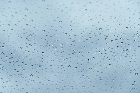 有多云背景的窗户玻璃表面有雨滴