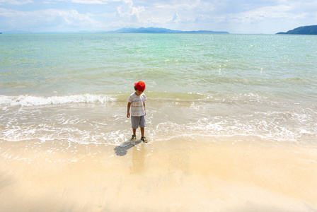 亚洲男孩在泰国海和白沙滩玩耍。