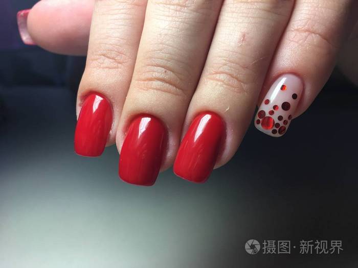 时尚的红色指甲长指甲上有红色糖果