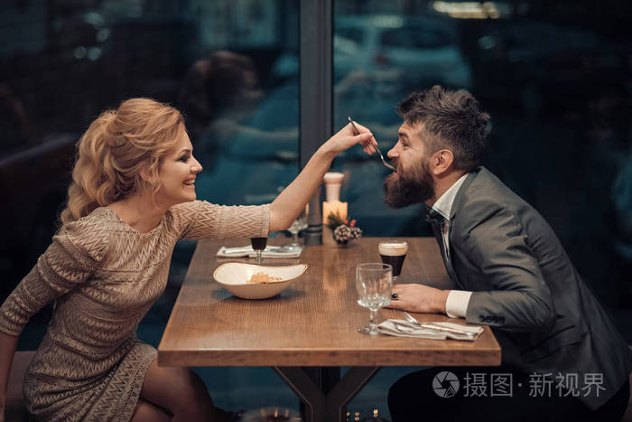 约会在浪漫的关系爱情情人节与性感的女人和胡须的男人在餐厅恋爱的