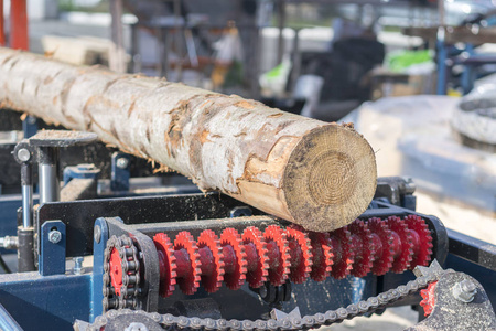 木工企业。木工切割机。一台便携式木材铣床上的部分碾磨原木