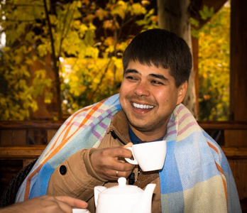 特写一个男人喜欢在户外喝一杯茶的肖像。 秋天的气氛