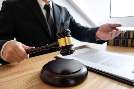 法律咨询和司法概念男性咨询律师或公证人工作的文件和合同文件的重要案件和木槌黄铜秤在法庭。