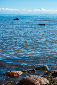 拉脱维亚蓝色天空下海水中的巨大粗糙岩石