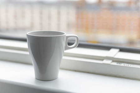 窗台上的一杯咖啡。 大窗户。 斯堪的纳维亚风格。 复制空间