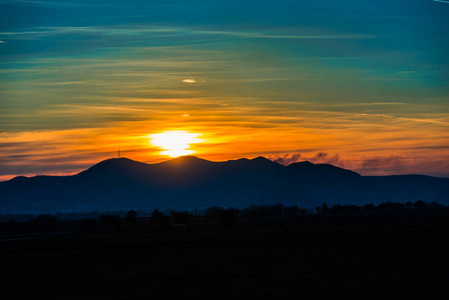 宁静的夕阳天空和地平线上的山影