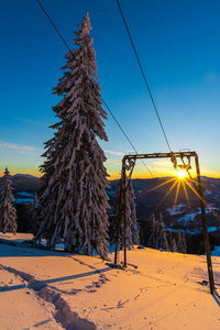 日落的天空和白雪覆盖的树木，冬季滑雪场，冬季山脉和滑雪电梯