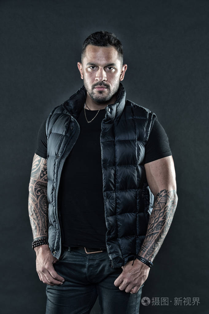 纹身文化理念.男人残酷的未刮胡子的西班牙人的外表纹身的手臂.带