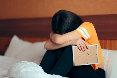 死了的女孩伤心沮丧的女孩哭了,分手后抱着相框的照片照片
