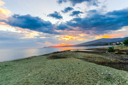 夕阳下空荡的海滨，隐藏着太阳和彩霞