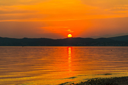 橘的红日落日天空，太阳在湖水之上