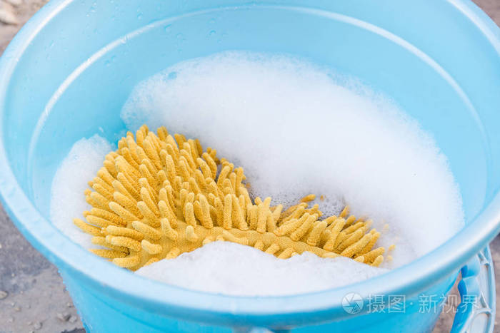海绵和泡沫在桶里肥皂水中的海绵用于洗涤的肥皂水和海绵