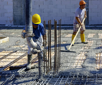 建筑工人在混凝土浇筑工程中以钢筋形式压实液态水泥