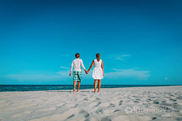 幸福恩爱的夫妻,在热带的海滩上行走