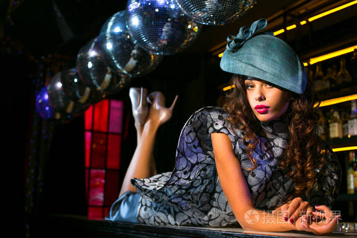 性感的年轻女人躺在夜总会的酒吧里