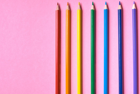 粉红糊背景上的彩色铅笔关闭。 一套彩色铅笔复制空间。 蜡笔。 俯视平躺。 回到学校的大学概念。 抽象背景。 彩虹彩虹