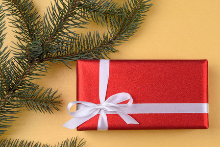 圣诞背景与红色礼品盒和杉树枝在金色背景自由空间。 平躺顶部视图，复制空间