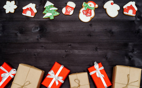 圣诞自制姜饼饼干和礼品盒边框在深色木制背景复制空间。 俯视平躺。 圣诞老人，圣诞老人