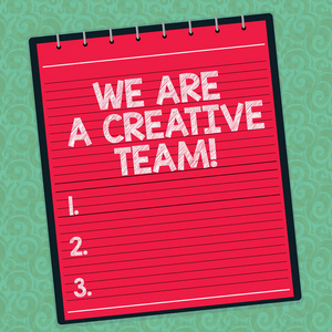 文字书写文本我们是一个创造性的团队。创意的商业理念团队同事头脑风暴工作在水印打印背景上的螺旋顶部彩色记事本照片