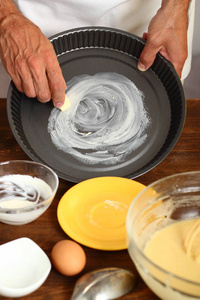 做酸奶油柠檬蛋糕。 准备蛋糕盘烘焙。 用人造黄油或黄油润滑。