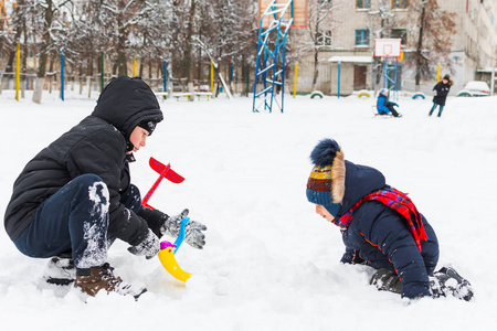 两个男孩在冬天在雪地里玩耍